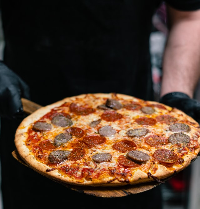 a man holding a pizza